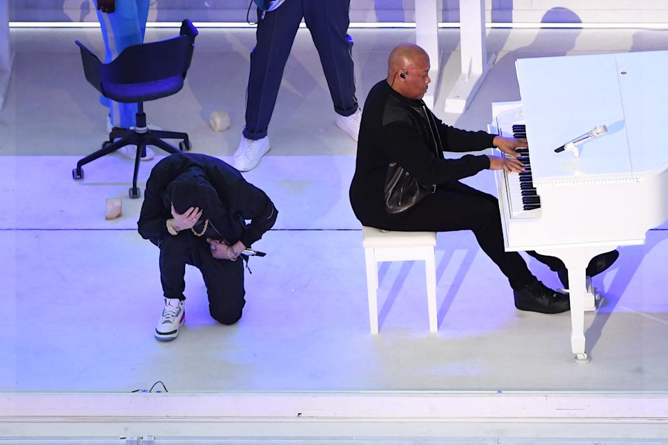 TOPSHOT - Le rappeur américain Eminem s'agenouille sur scène alors qu'il se produit avec le rappeur américain Dr. Dre lors de la mi-temps du match LVI du Super Bowl entre les Rams de Los Angeles et les Bengals de Cincinnati au SoFi Stadium à Englewood, Californie, le 13 février 2022. (Photo) Par VALERIE MACON/AFP) (Photo par VALERIE MACON/AFP via Getty Images)