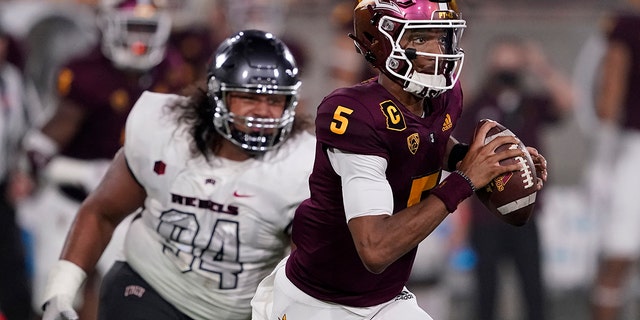 Le quart-arrière de l'État de l'Arizona Jayden Daniels (5) cherche à lancer le joueur de ligne défensive de l'UNLV Kolo Oseki (94) lors d'un match le 11 septembre 2021 à Tempe, en Arizona.